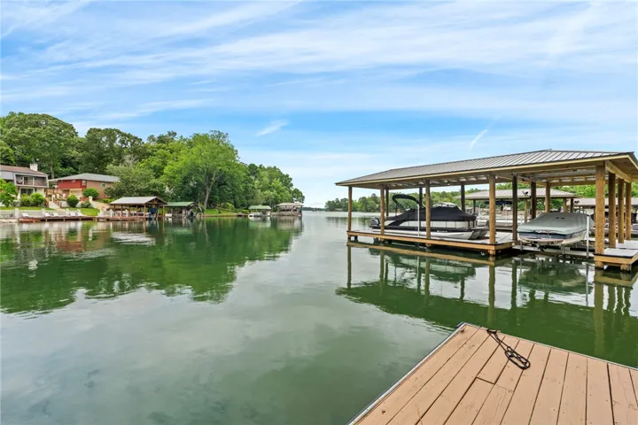 Boathouses line the tranquil waterfront, offering direct lake access for watercraft.