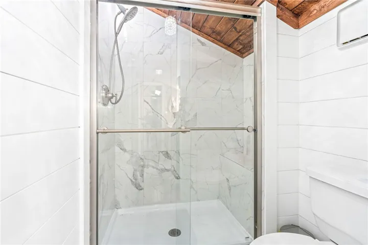 Marble-patterned tile and a glass enclosure define this pristine walk-in shower.