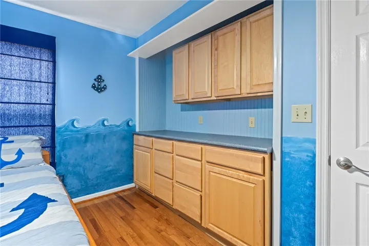 Hardwood floors complement built-in cabinetry, creating a well-organized and functional space.