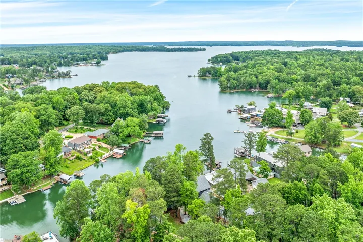 Discover serene lakeside living with extensive water frontage and mature tree cover providing privacy.