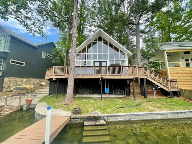 A charming lakeside retreat boasts a spacious deck for outdoor living and direct water access.