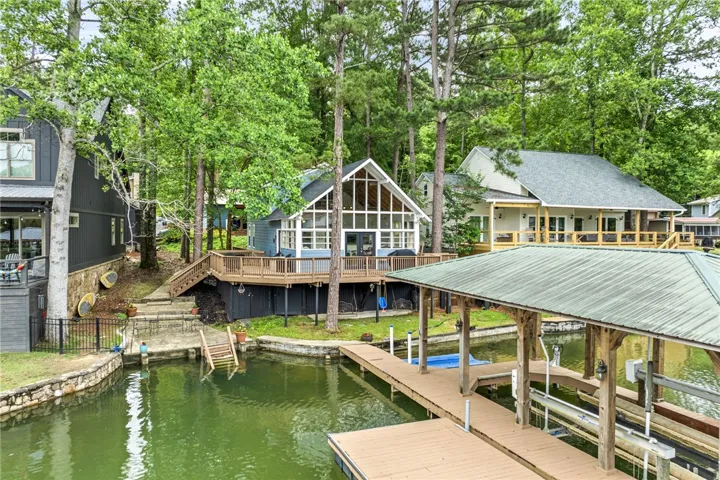 Lakeside living beckons with a private dock, expansive deck, and a wall of windows offering serene waterfront views.