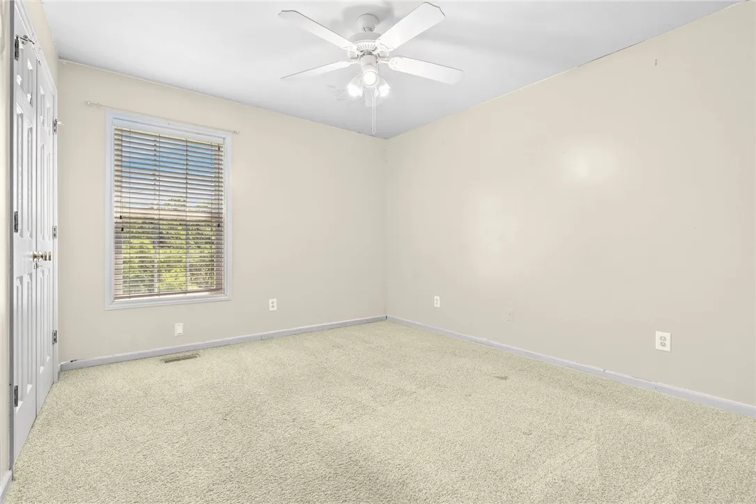 A well-proportioned bedroom offers plush carpeting and a bright window with exterior views.