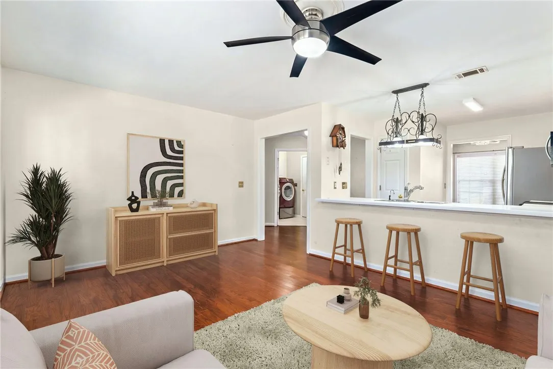 Rich hardwood flooring extends through this inviting living area, seamlessly connecting to a breakfast bar.