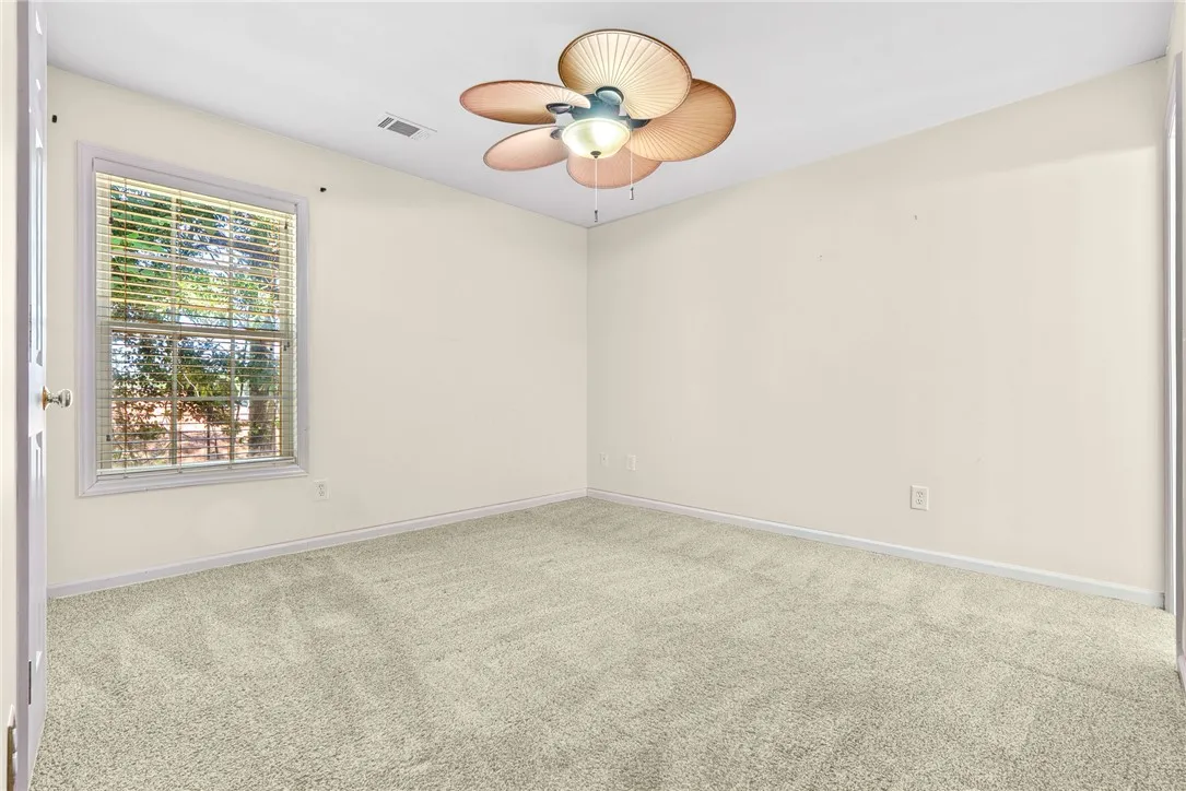 A well-lit bedroom with a ceiling fan, offering a comfortable and airy retreat.