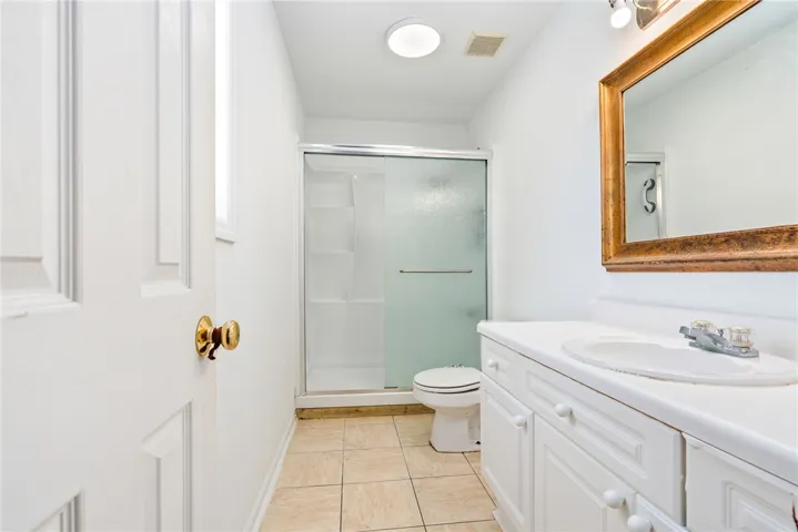 This bathroom features a sleek shower and vanity, offering modern comfort and convenience.