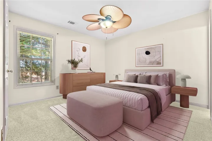 A tranquil haven for rest and rejuvenation, this room features soft carpet and a cooling ceiling fan.