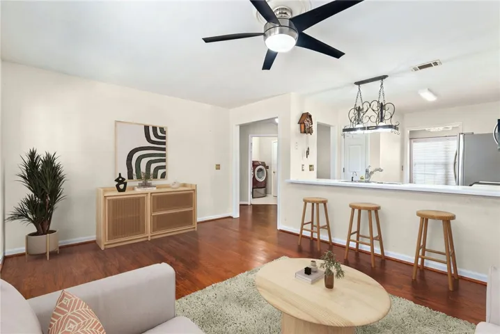Rich hardwood flooring extends through this inviting living area, seamlessly connecting to a breakfast bar.