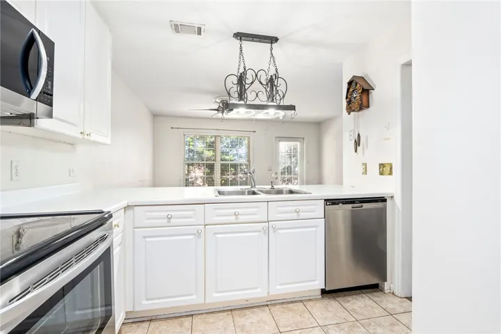 This bright kitchen features functional appliances and a clear view to the outdoors.