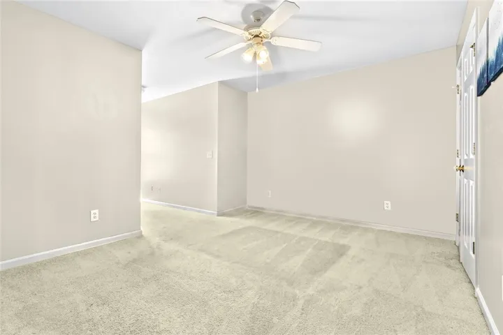 A spacious room offers comfortable carpeting and a cooling ceiling fan.