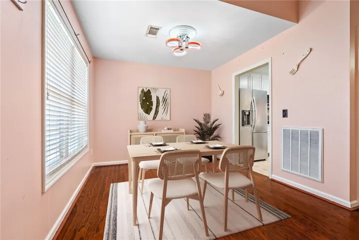 This inviting dining area features warm wood flooring and ample natural light, perfect for everyday meals.