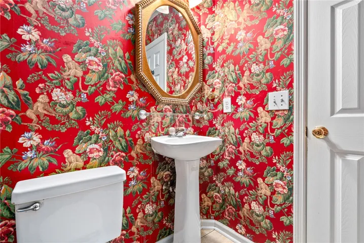 This powder room features a classic pedestal sink, perfect for guests.