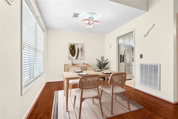 Rich hardwood flooring complements a chic dining space, ideal for memorable meals.
