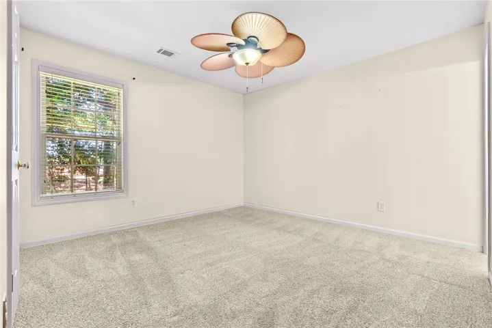 A well-lit bedroom with a ceiling fan, offering a comfortable and airy retreat.