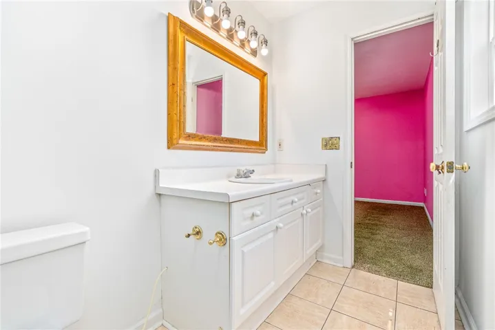 This bathroom features a pristine vanity with ample counter space and classic tile flooring.