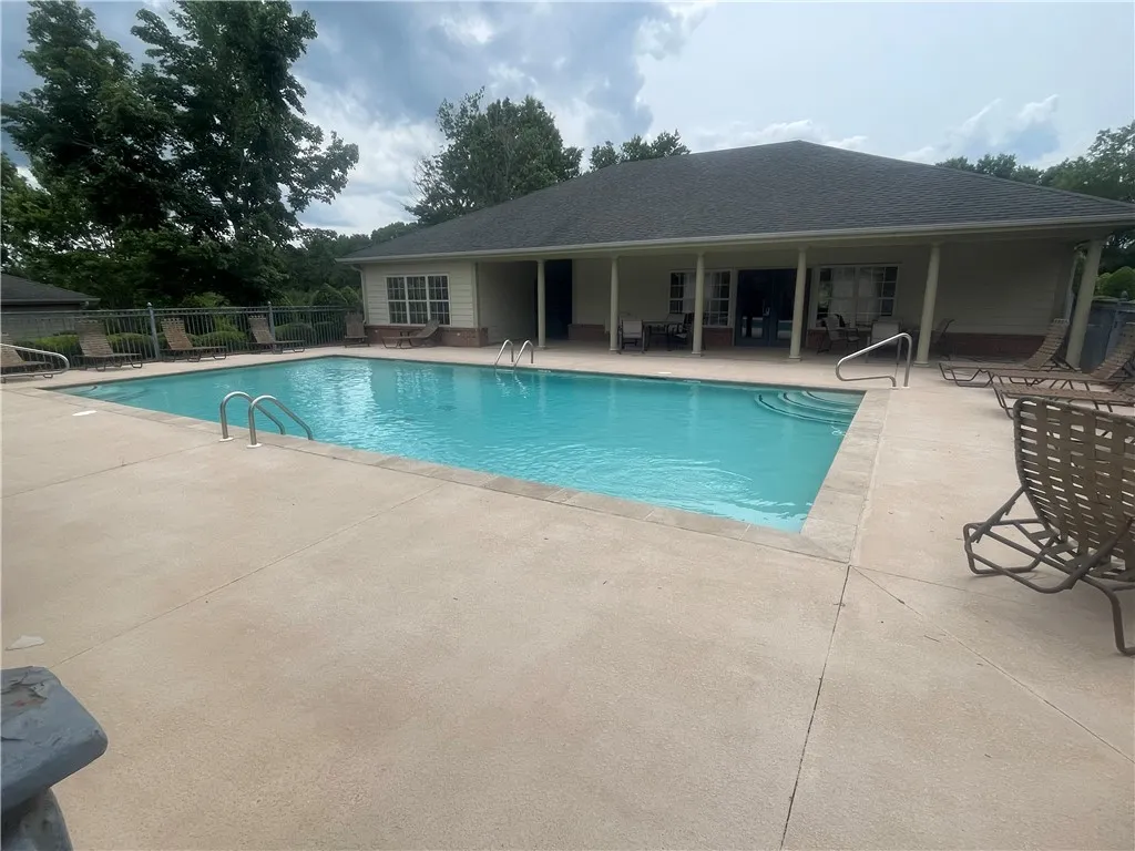 Relax and refresh by the crystal-clear pool, surrounded by lush trees and a comfortable lounging area.