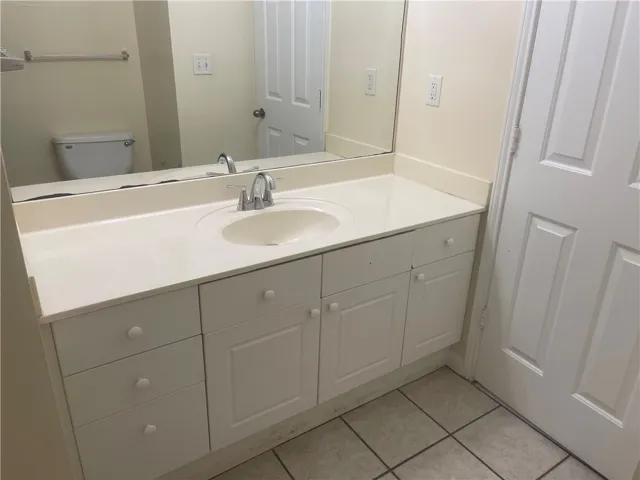 This bright bathroom offers a single vanity with ample storage and tiled flooring.