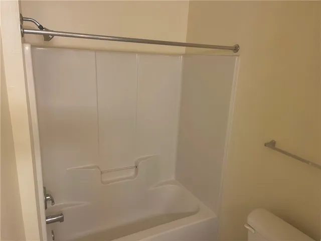 This clean and inviting bathroom features a convenient shower and bathtub combination.