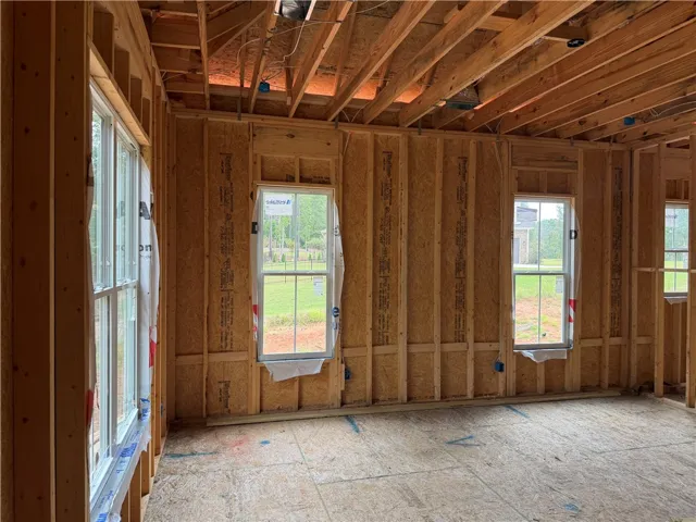 Exposed framing and subflooring await personalization in this unfinished interior under construction.