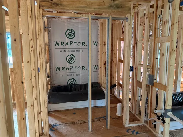 Exposed wood framing reveals the early stages of a master bathroom installation.