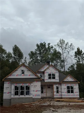 New residential construction in progress showcases a multi-gabled roofline and framed window openings.