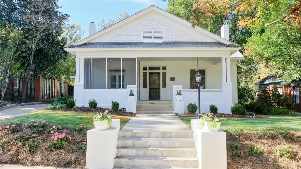 This charming home offers a welcoming facade with a screened porch and manicured landscaping.