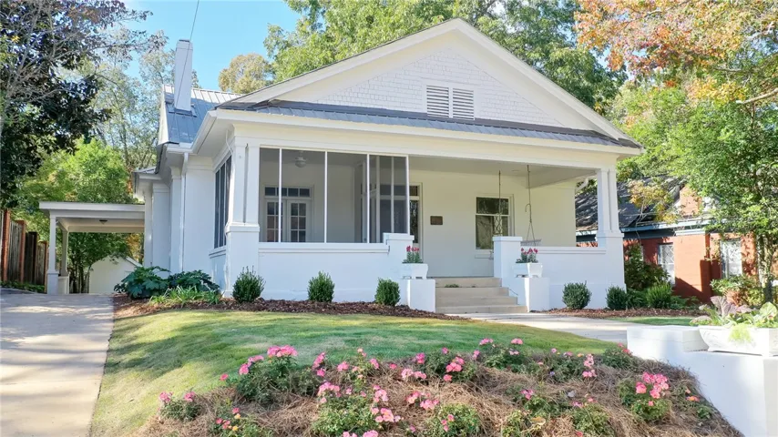 This charming residence features a inviting porch, a covered carport, and a well-maintained yard.