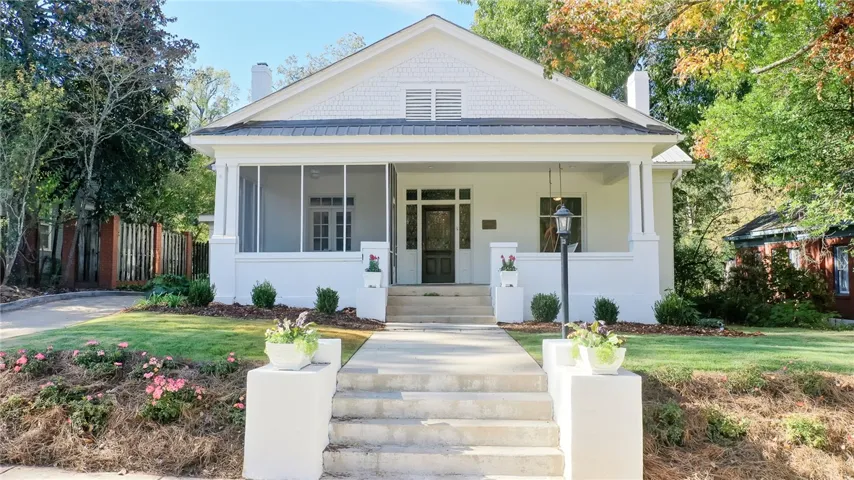 This charming home offers a welcoming facade with a screened porch and manicured landscaping.