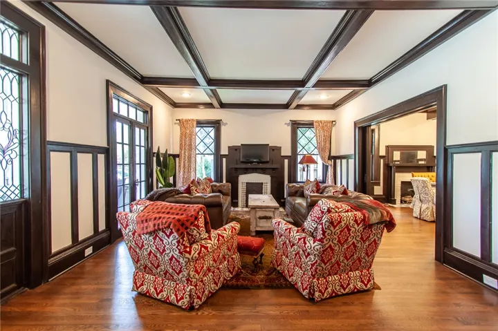 This grand living room features rich wood accents and a cozy fireplace, creating an inviting​​‌​​​​‌​​‌‌​‌‌​​​‌‌​‌​‌​‌​​​‌​​ ambiance.