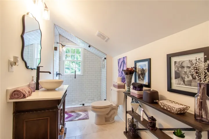 This bathroom features a contemporary vanity, a glass-enclosed shower, and elegant tile flooring.