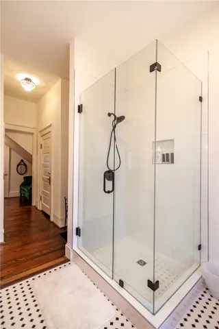 This bathroom features a sleek glass-enclosed shower, offering a blend of classic and modern design elements.