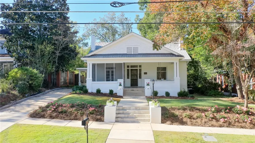 A charming home welcomes with a screened porch and well-maintained lawn.
