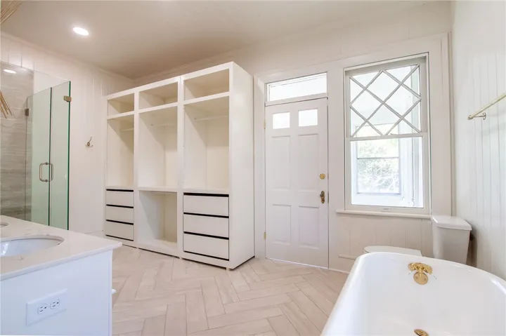 This spacious bathroom offers a relaxing retreat with ample storage and elegant fixtures.