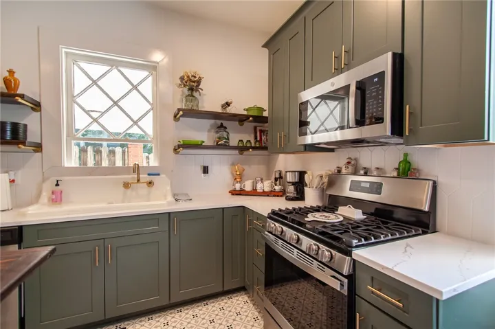 This modern kitchen features stylish cabinetry, sleek appliances, and a charming window above the sink.