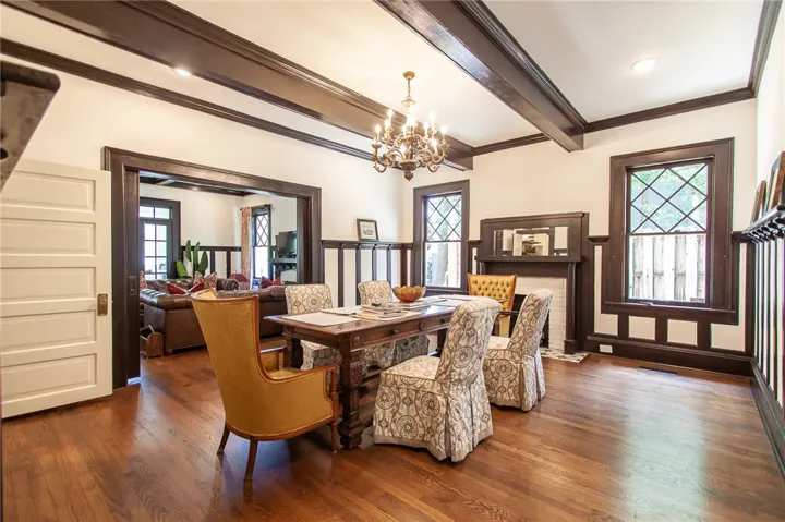Elegant gathering space featuring rich hardwood floors and architectural beams, perfect for entertaining.