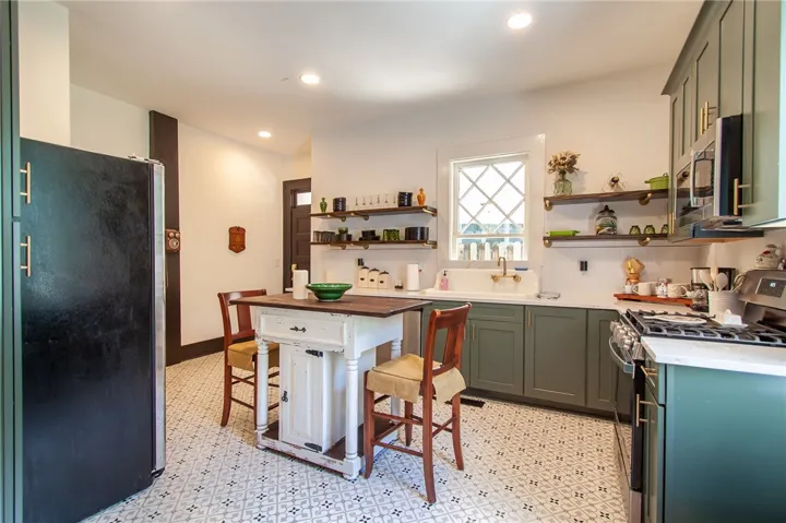 This charming kitchen features patterned flooring and sleek cabinetry.