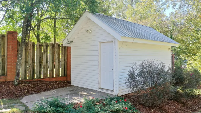This charming utility shed offers practical storage amidst lush, mature landscaping and a private yard.