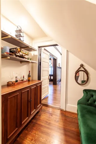 This inviting space features rich hardwood flooring and a stylish built-in bar, perfect for entertaining.