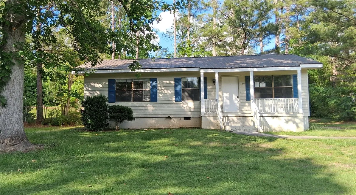 Charming home with welcoming porch and mature trees for natural shade.