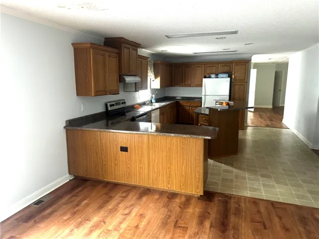 Functional kitchen with ample cabinetry and mixed flooring offers practical design for everyday living.