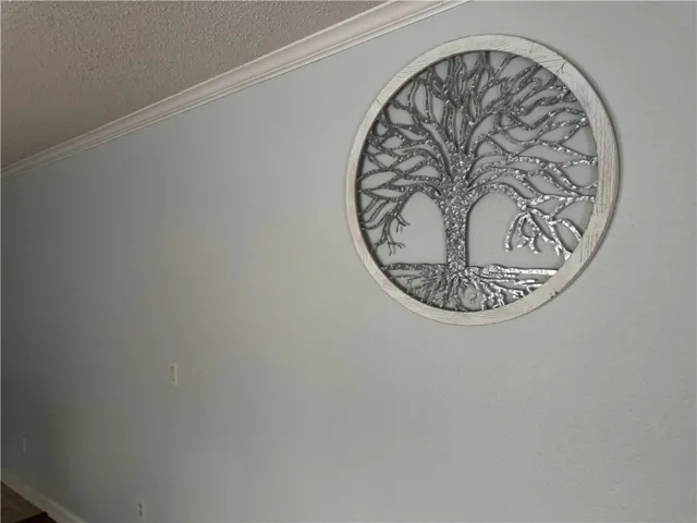 Adorn your interior space with a distinct tree-inspired metallic wall decor piece, complemented by elegant crown molding.