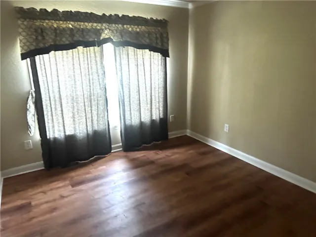 This airy room features warm wood flooring and ample natural light from its large window.