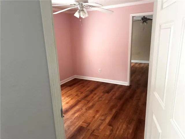 This interior room features wood flooring and a ceiling fan, offering a comfortable atmosphere.