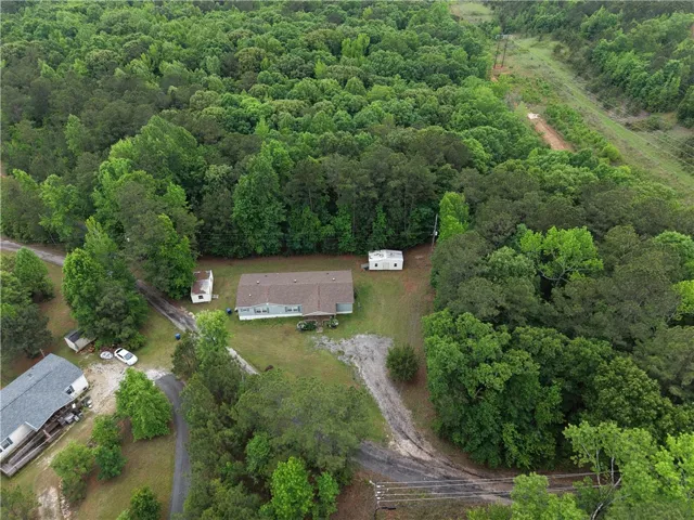 Observe this secluded property nestled amidst lush, verdant woodlands, offering serene natural privacy.