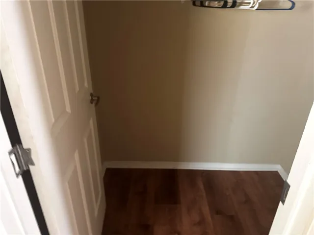 Functional closet with paneled door and rich hardwood flooring, ready for organization.