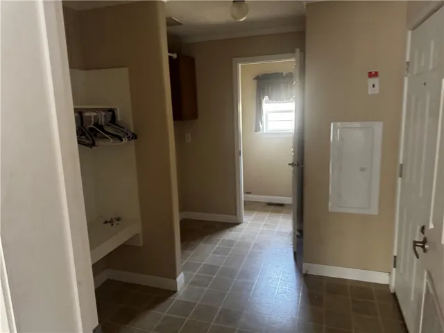 Functional utility space with durable tile flooring and a built-in storage nook.