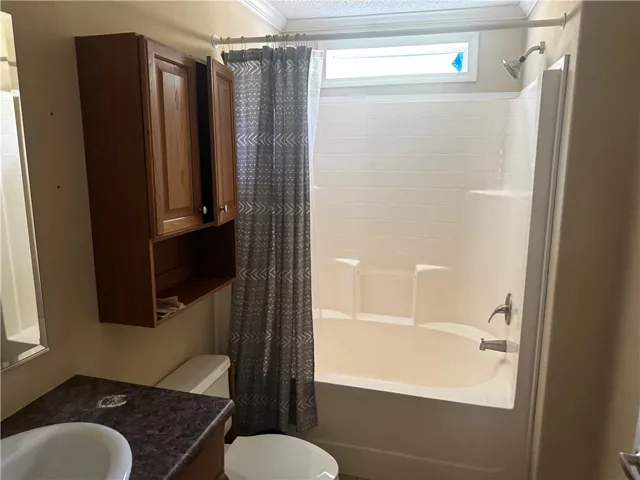 This bathroom features a classic bathtub-shower combination with a transom window for ample light.