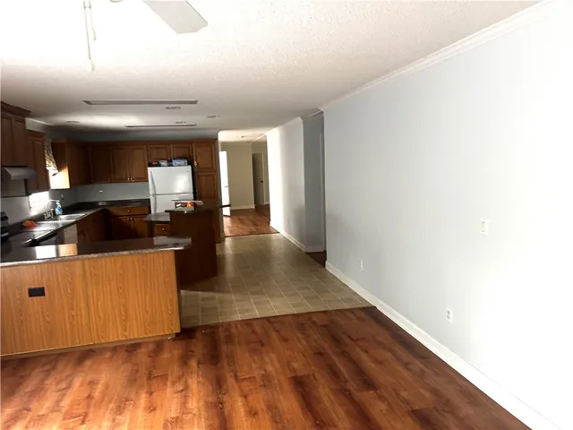 This open concept kitchen and living area features diverse flooring and ample cabinetry.