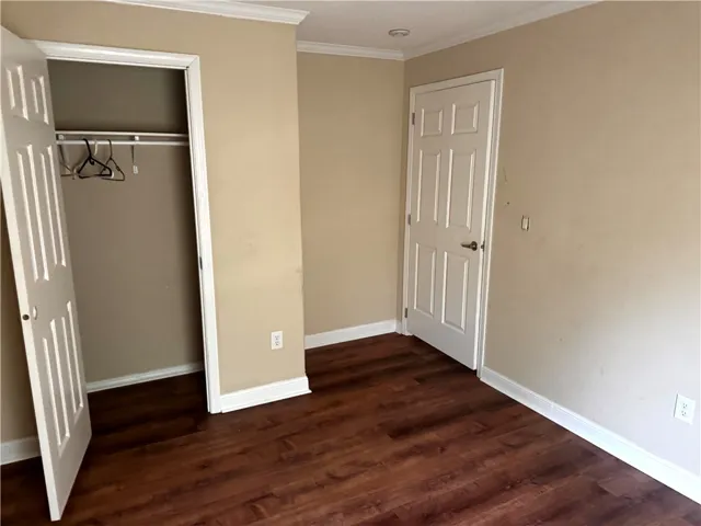 This cozy bedroom offers rich wood flooring and a convenient built-in closet.