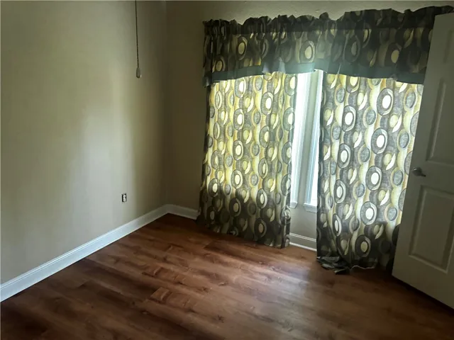 This versatile space offers durable wood-look flooring and a sun-filled window, perfect for various uses.